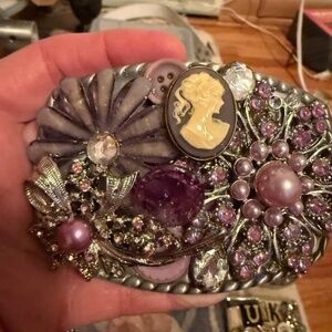 Light purple brooches and a Cameo on this 4 x 3 inch belt buckle